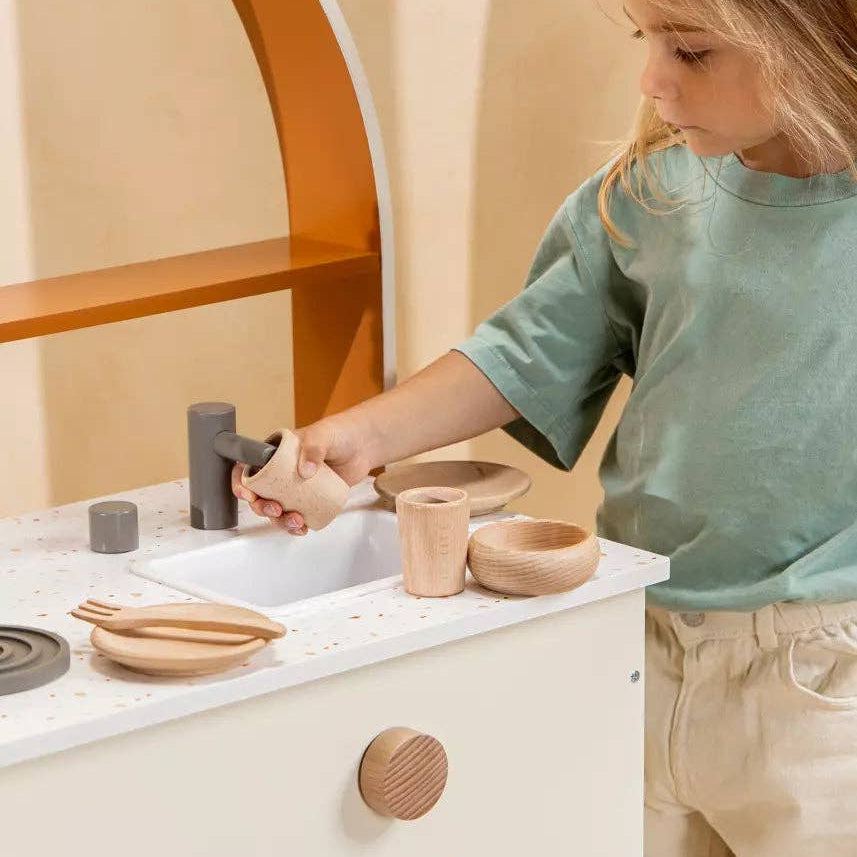 Child playing with wooden kitchen toys 