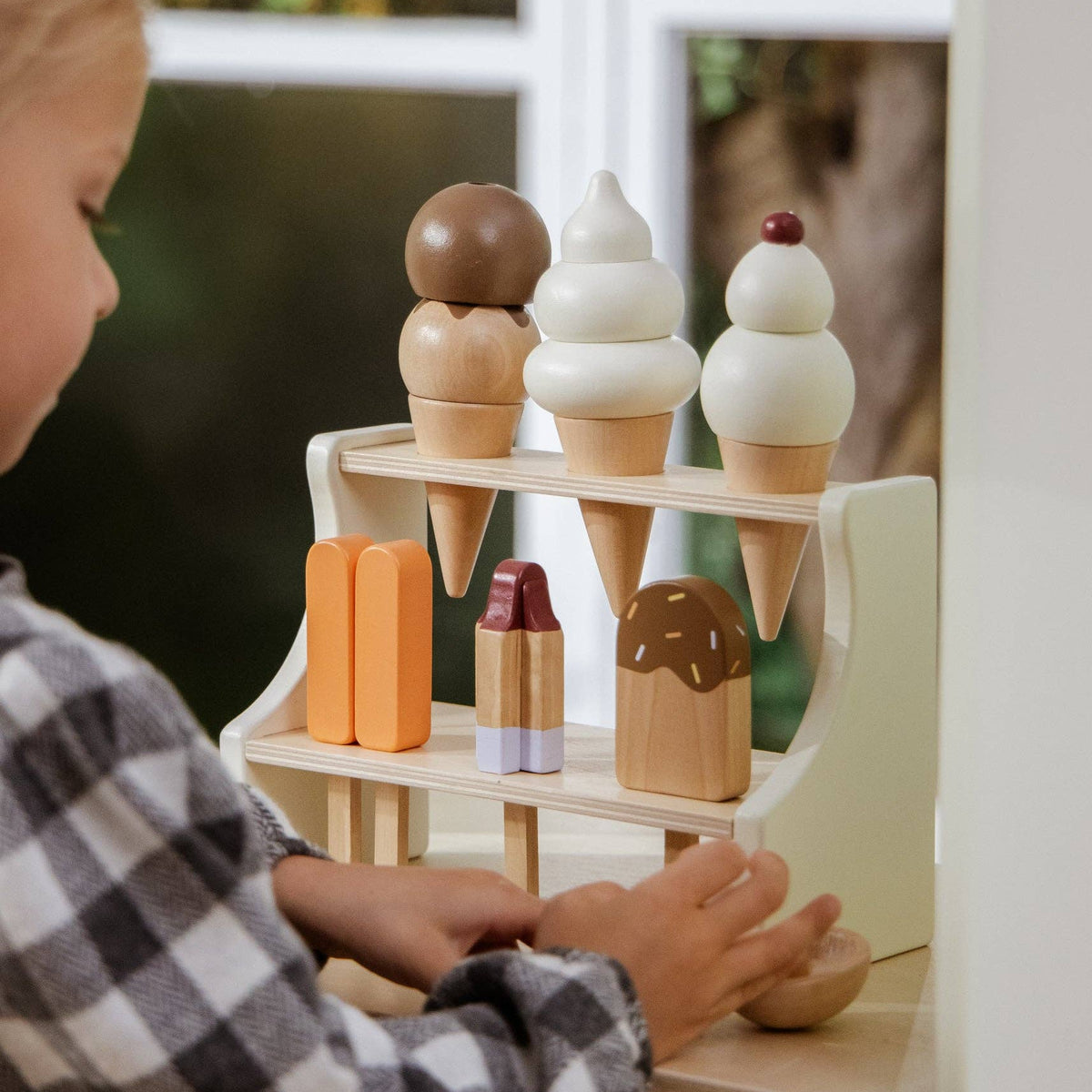 Child playing with a wooden ice cream set