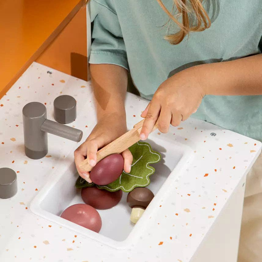 Child playing with wooden vegetable toys 