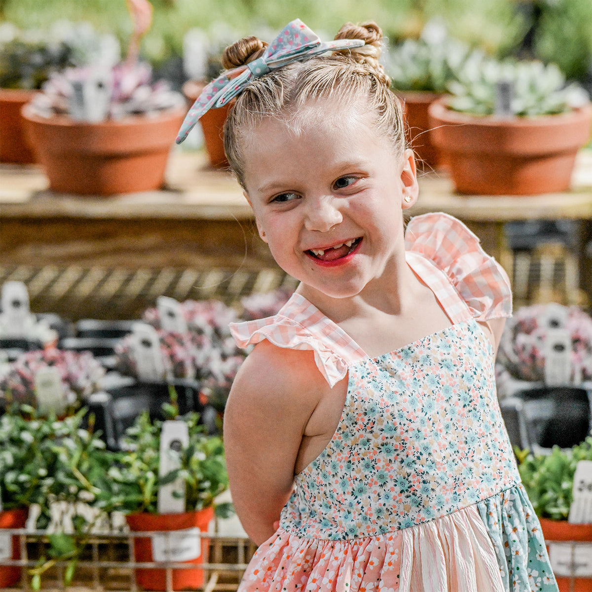 Multi Print Charlotte Party Dress close up with matching hair bow lifestyle image